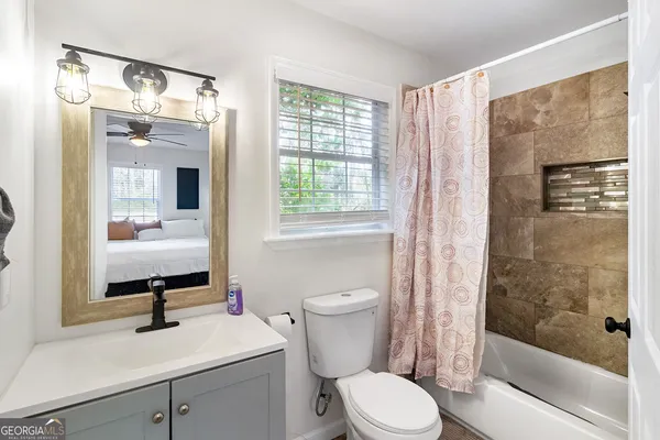 a bathroom with a sink toilet a mirror and shower