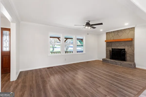 an empty room with windows and a fireplace