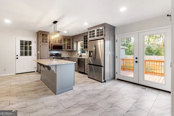 a kitchen with stainless steel appliances granite countertop a refrigerator a stove a sink and a cabinets