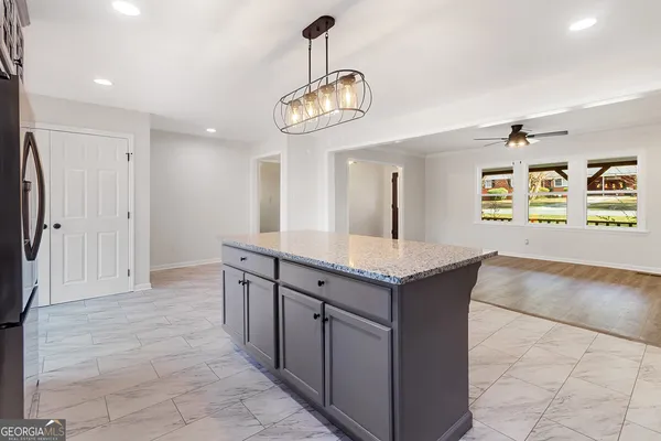 a kitchen with stainless steel appliances granite countertop a refrigerator a sink and a stove