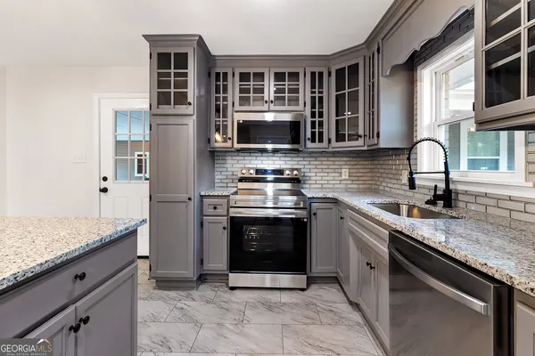 a kitchen with stainless steel appliances granite countertop a stove microwave and cabinets