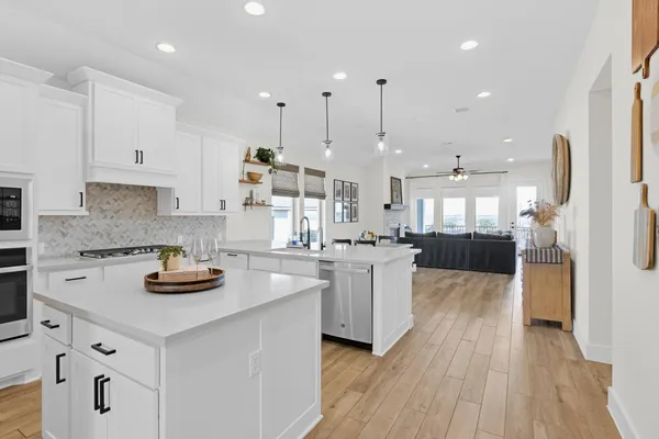 a kitchen with white cabinets and appliances