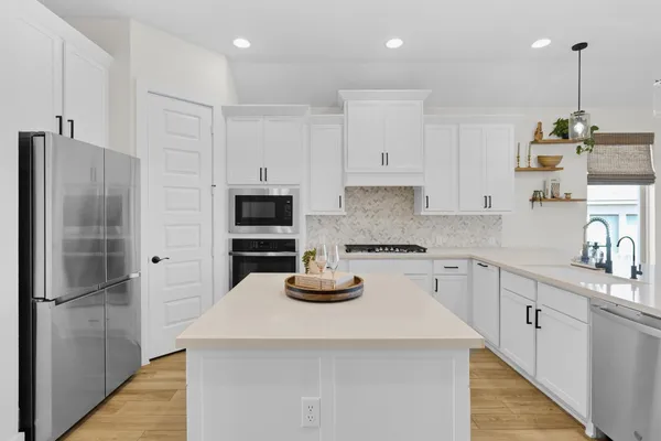 a kitchen with a refrigerator and white cabinets