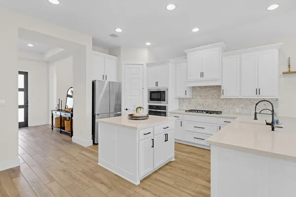 a kitchen with stainless steel appliances a stove refrigerator sink and cabinets