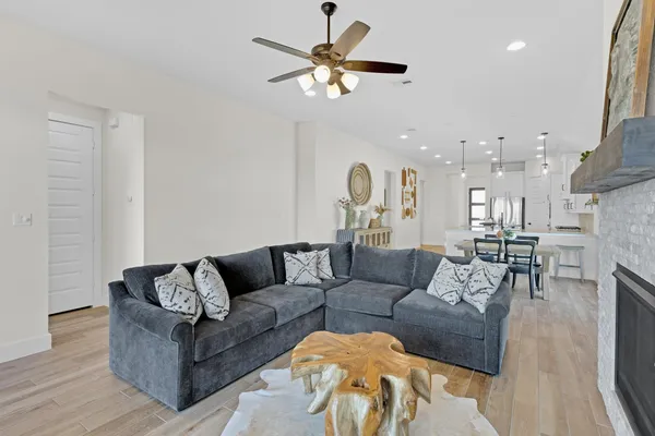 a living room with furniture kitchen view and a chandelier