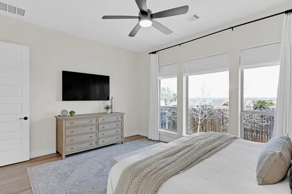 a bedroom with a bed television on desk and a flat screen tv