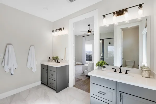 a bathroom with a double vanity sink mirror and shower