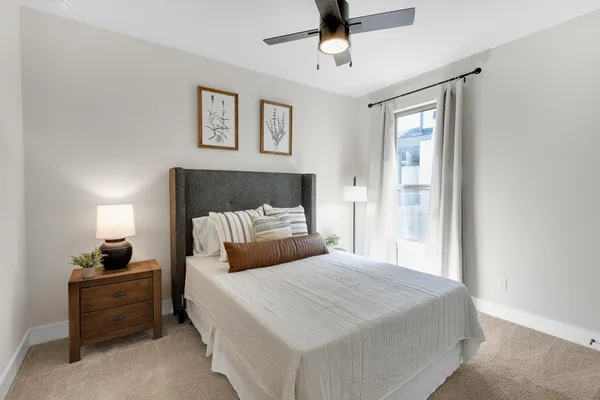 a bedroom with a large bed and a chandelier