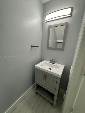 a utility room with a sink a mirror and vanity