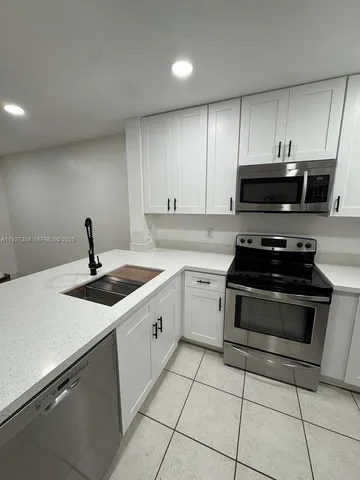 a kitchen with a sink and appliances