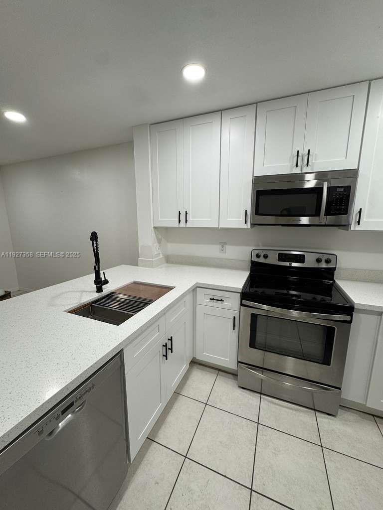 12605 Southwest 54th Court, Unit 12605 Miramar, FL 33027 - Photo 3 of 13 a kitchen with a sink and appliances