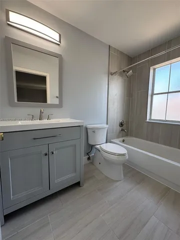 a bathroom with a double vanity sink toilet mirror and bathtub