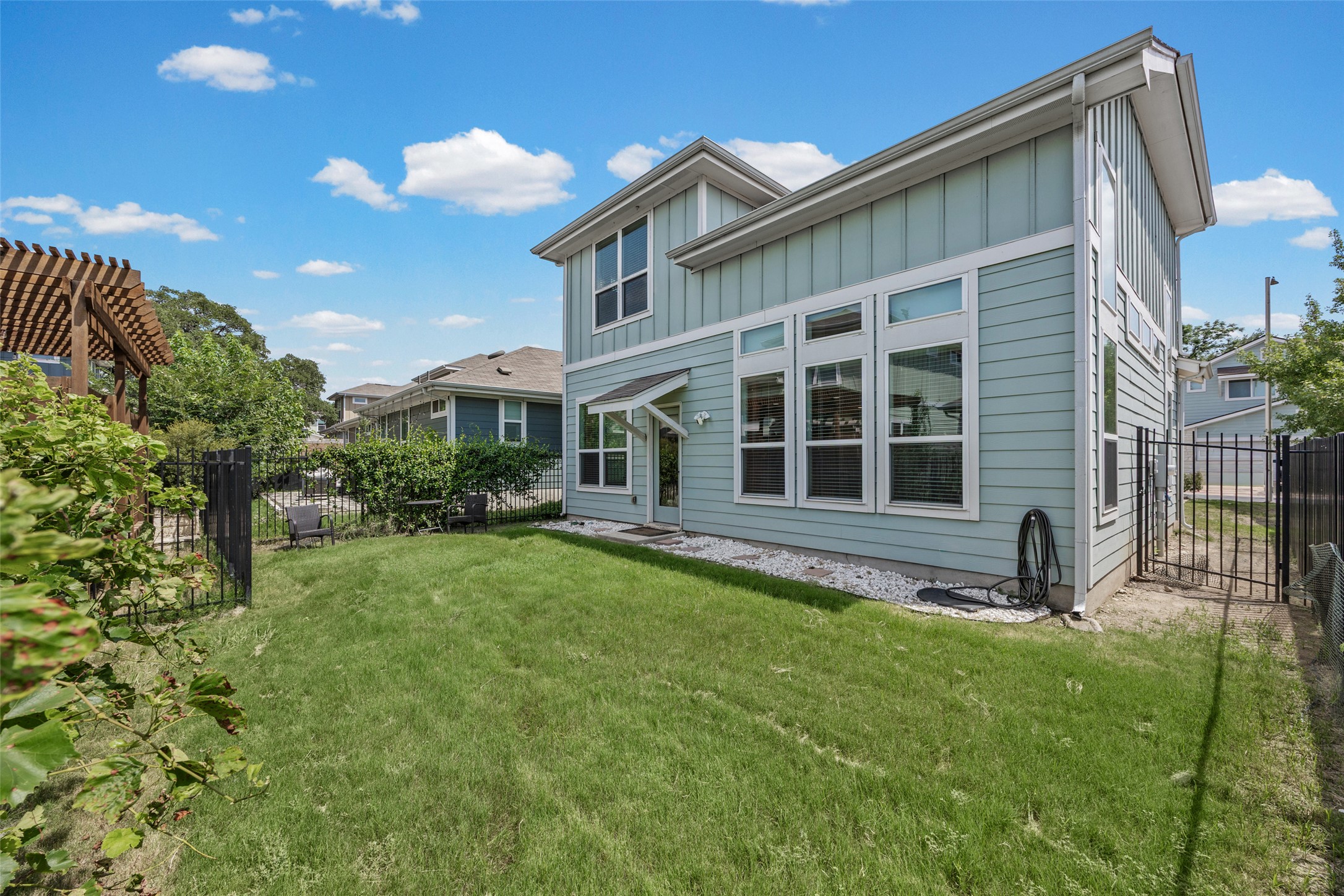 1408 Homespun Road Austin, TX 78745 - Photo 19 of 20 A well-maintained lawn stretches beside a contemporary residence featuring sleek siding and numerous windows.