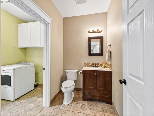 a view of bathroom with a toilet sink and mirror