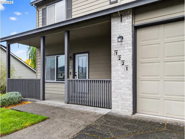 a view of a house with a small yard and wooden fence and large window
