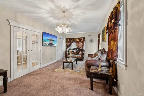 a living room with furniture a chandelier and a window