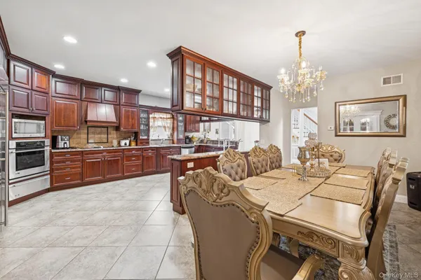 a living room with stainless steel appliances furniture a rug and a kitchen view