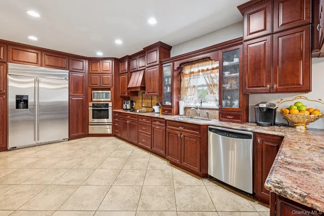 a kitchen with stainless steel appliances granite countertop a refrigerator and wooden cabinets