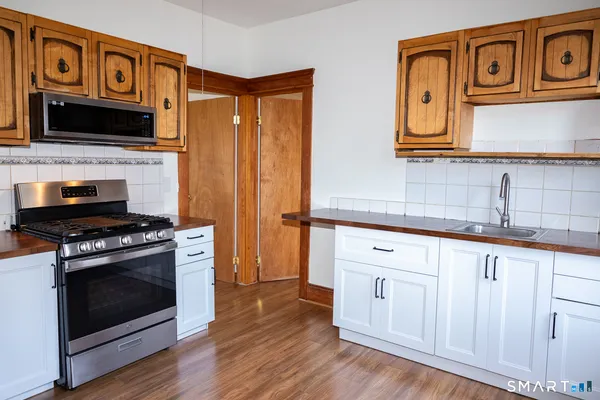 a kitchen with stainless steel appliances granite countertop a stove a sink and a microwave