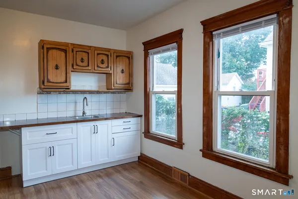 a kitchen with stainless steel appliances granite countertop a stove a sink and a large window