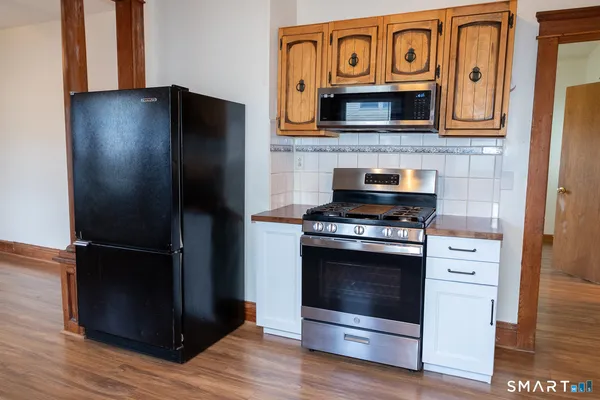 a kitchen with stainless steel appliances granite countertop a stove microwave and refrigerator