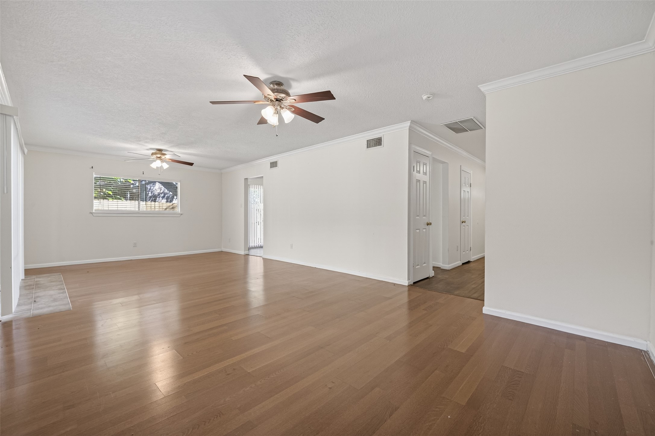 1106 East Red Cedar Circle Spring, TX 77380 - Photo 12 of 43 a view of an empty room with wooden floor and a window