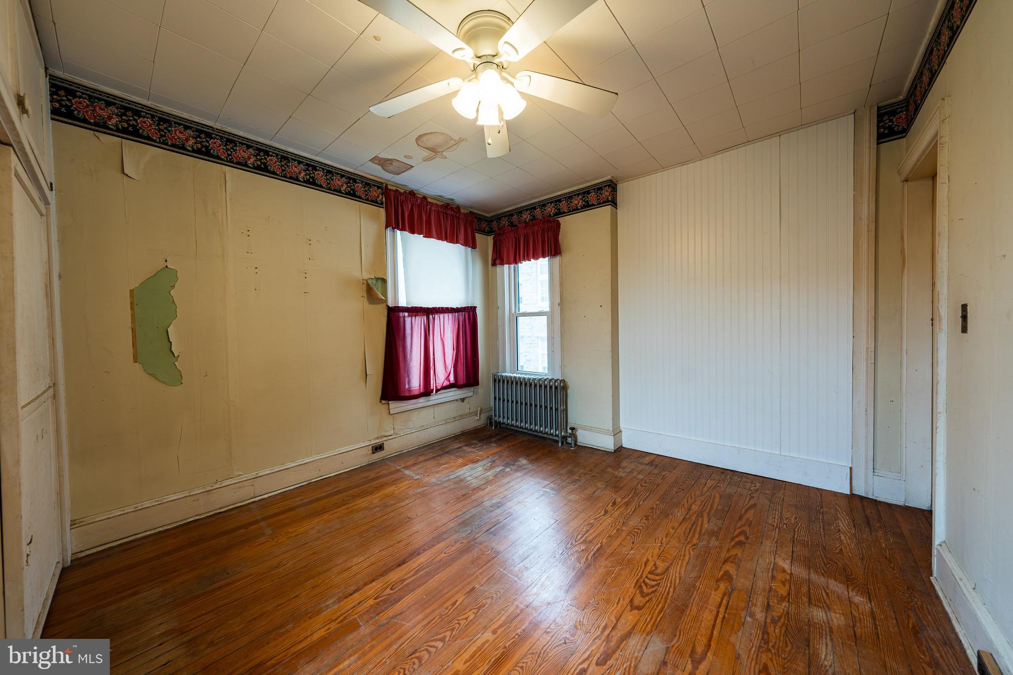 9 Church Lane Baltimore, MD 21208 - Photo 19 of 31 a view of an empty room with window wooden floor and a chandelier fan