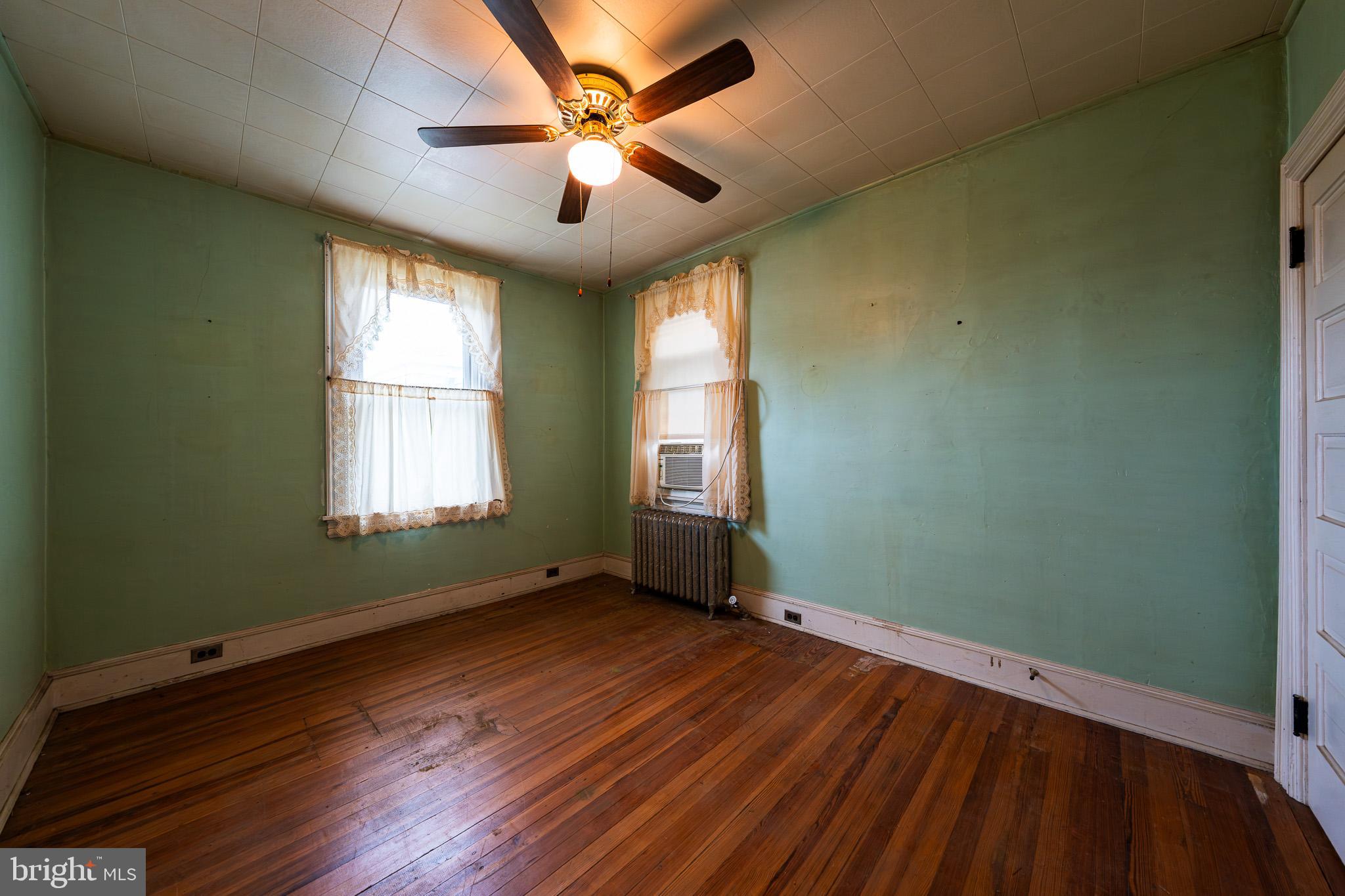 9 Church Lane Baltimore, MD 21208 - Photo 25 of 31 an empty room with wooden floor fan and windows