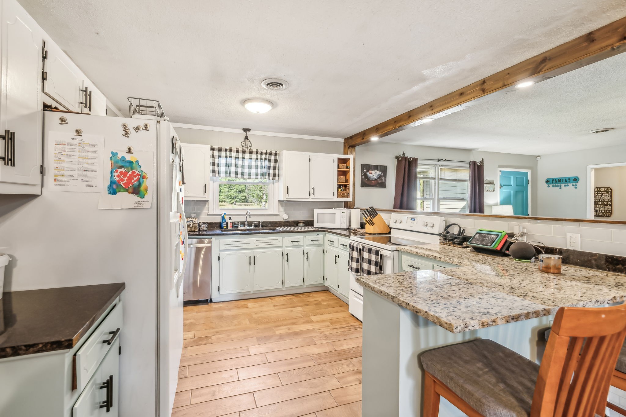 3016 Pocahontas Road Morrison, TN 37357 - Photo 6 of 47 a kitchen with granite countertop a stove a sink dishwasher and refrigerator with wooden floor