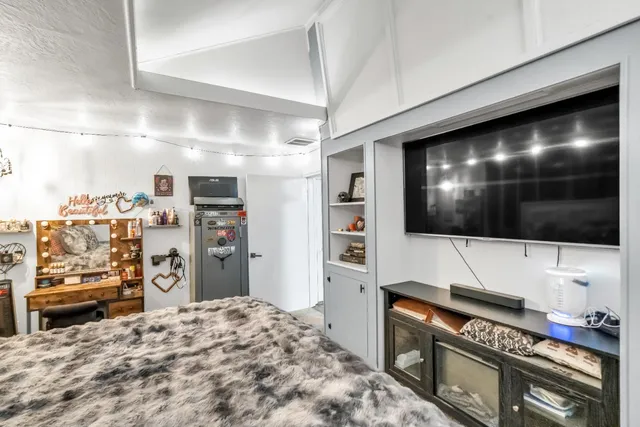 a bedroom with a bed next to a window