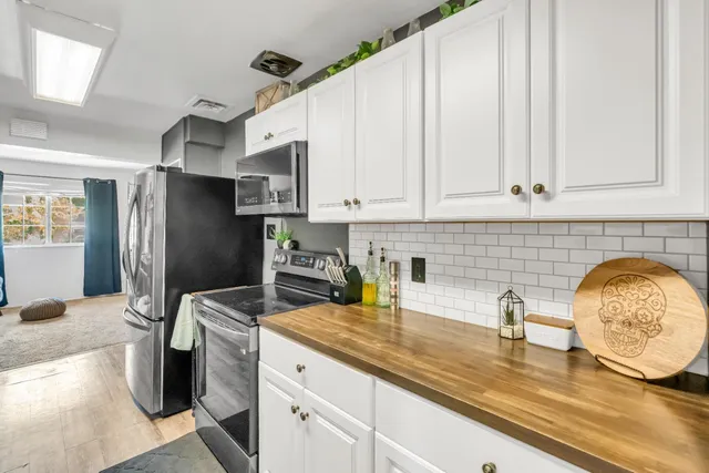 a kitchen with stainless steel appliances granite countertop a sink a refrigerator and a granite counter tops