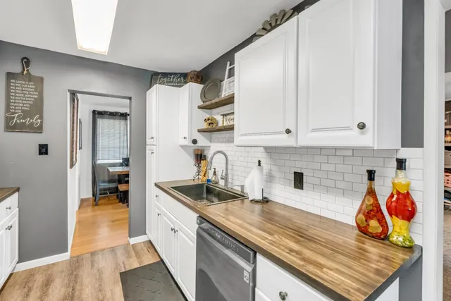a kitchen with stainless steel appliances granite countertop a sink dishwasher and cabinets with wooden floor