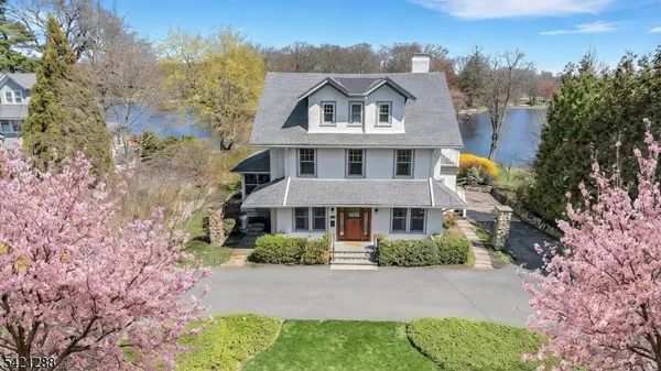 a view of a house with a big yard and large trees