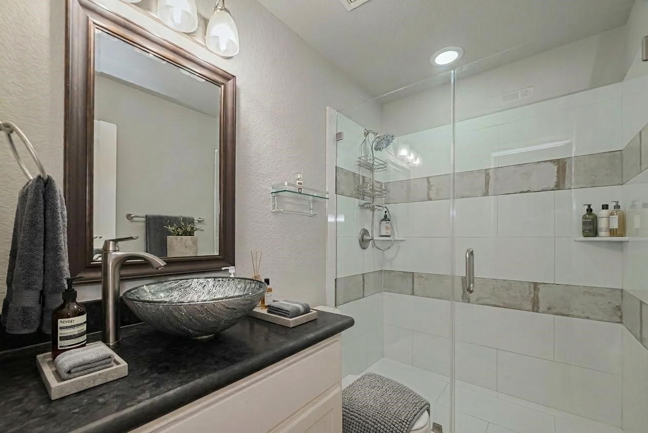 278 Capetown Montgomery, TX 77356 - Photo 19 of 27 a en suite bathroom with a granite countertop tub and a mirror