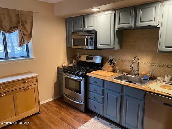 a kitchen with stainless steel appliances wooden cabinets and a stove top oven