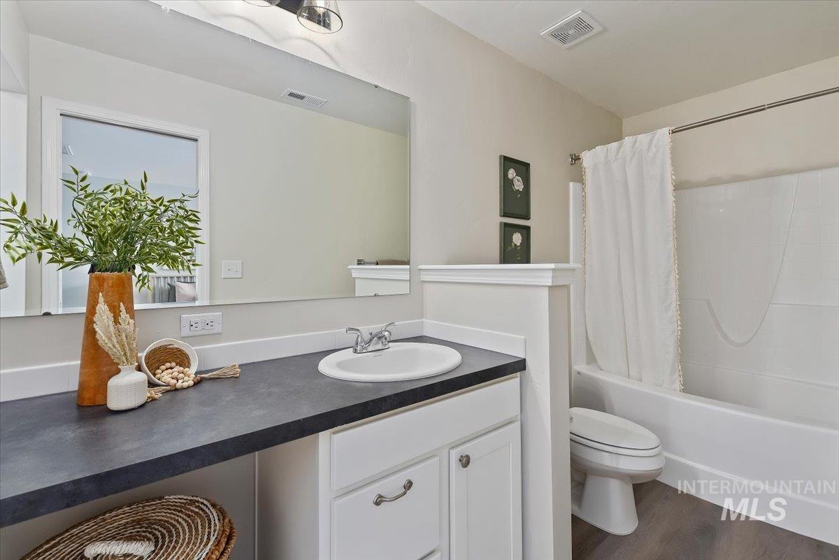 12781 Ashfield Street Caldwell, ID 83607 - Photo 23 of 36 Bathroom with vanity, shower / bathtub combination with curtain, and dark wood finished floors