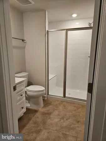 a white toilet sitting next to a shower