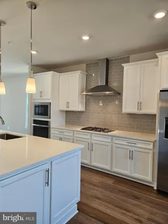 a kitchen with stainless steel appliances a stove a sink and white cabinets