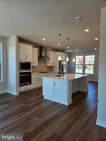 a large kitchen with wooden floors and stainless steel appliances