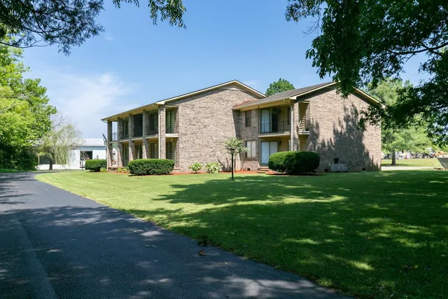 a front view of a house with a yard and trees