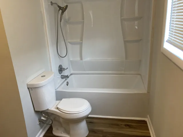 a bathroom with a toilet and a shower