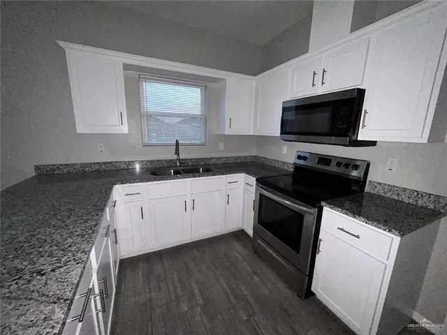 a view of a kitchen with a sink and a refrigerator