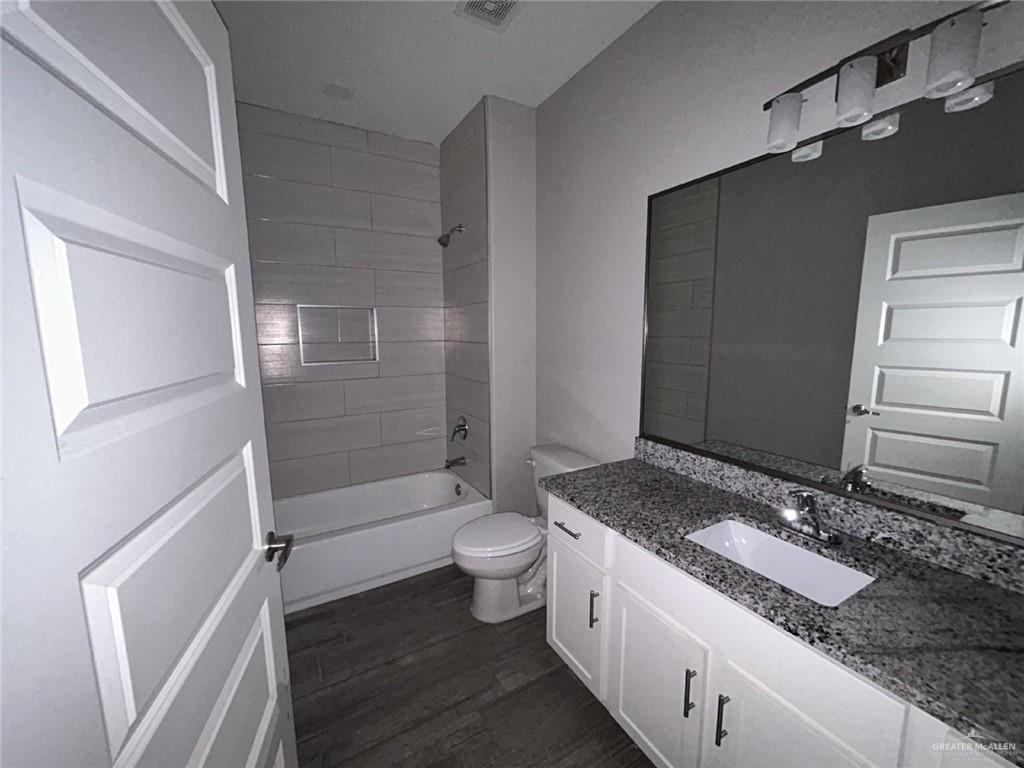 1905 Stauffer Street, Unit 4 Weslaco, TX 78596 - Photo 7 of 13 a bathroom with a granite countertop sink toilet and shower