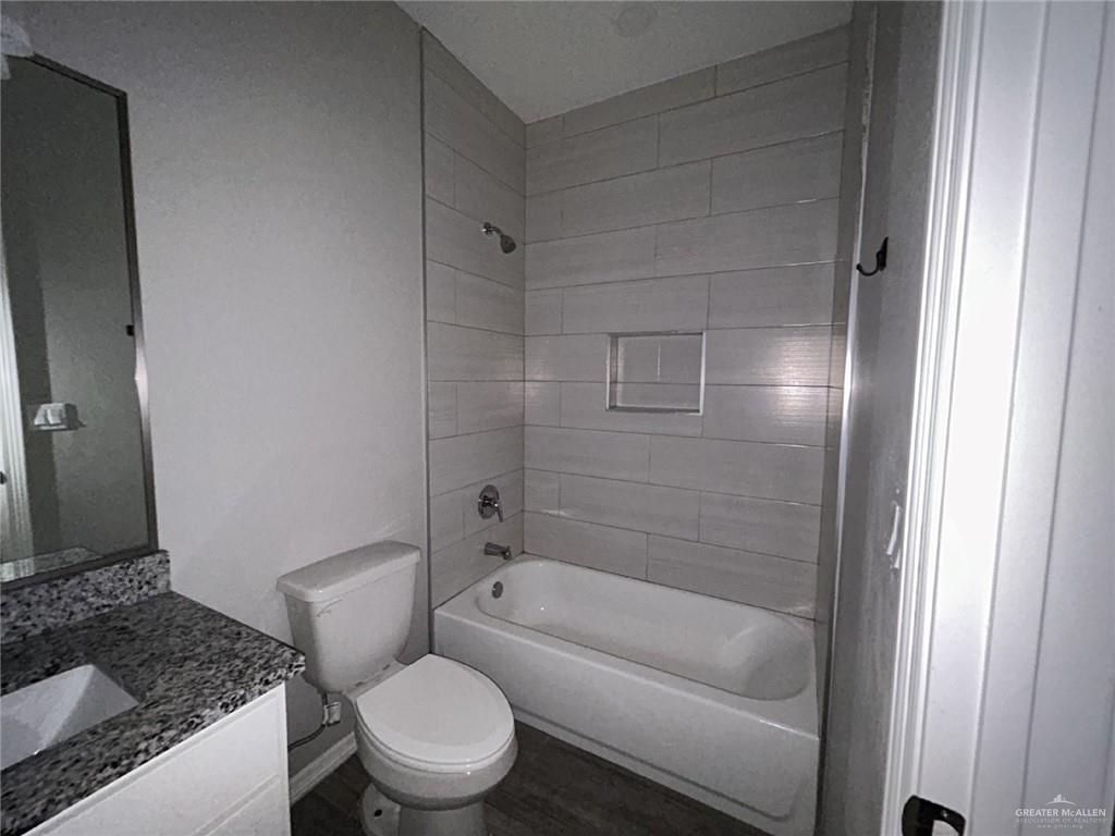 1905 Stauffer Street, Unit 4 Weslaco, TX 78596 - Photo 8 of 13 a bathroom with a granite countertop toilet a sink and bathtub