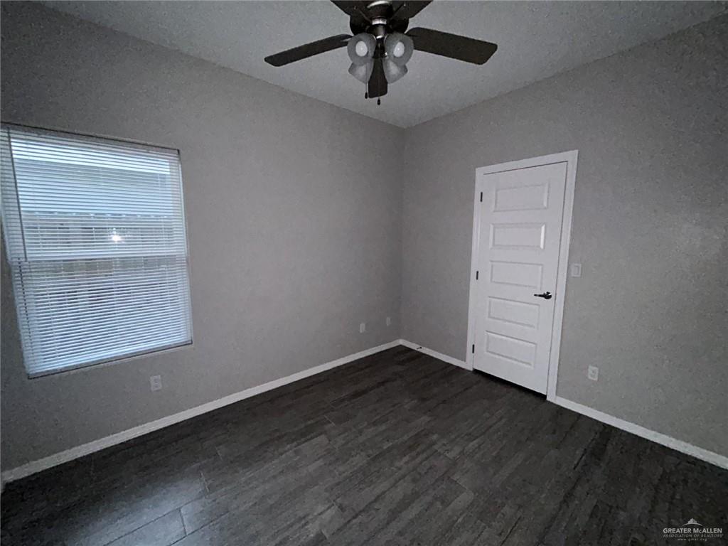 1905 Stauffer Street, Unit 4 Weslaco, TX 78596 - Photo 9 of 13 an empty room with wooden floor cabinet and windows