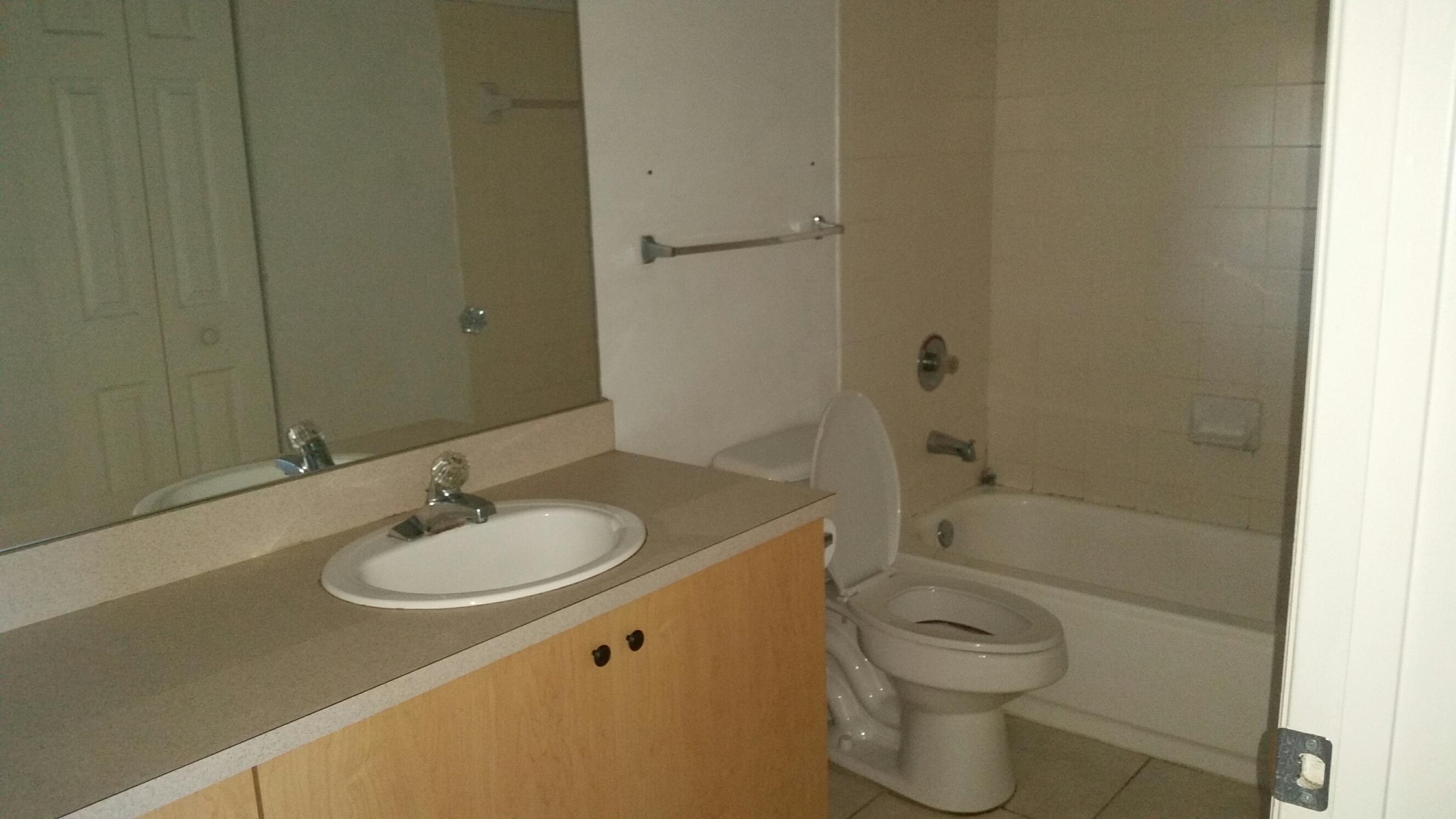 5064 Lantana Road, Unit 6107 Lake Worth, FL 33463 - Photo 15 of 26 a bathroom with a granite countertop sink toilet and shower