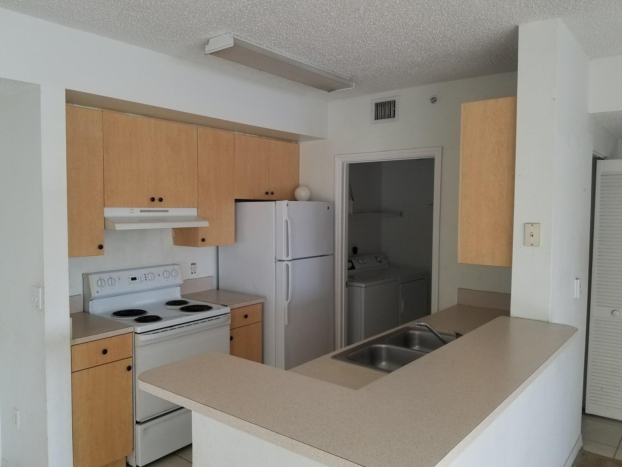 5064 Lantana Road, Unit 6107 Lake Worth, FL 33463 - Photo 6 of 26 a kitchen with a refrigerator and a sink