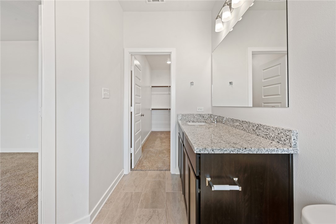 2412 Rooke Road Bryan, TX 77807 - Photo 26 of 35 a bathroom with a granite countertop sink a toilet and shower