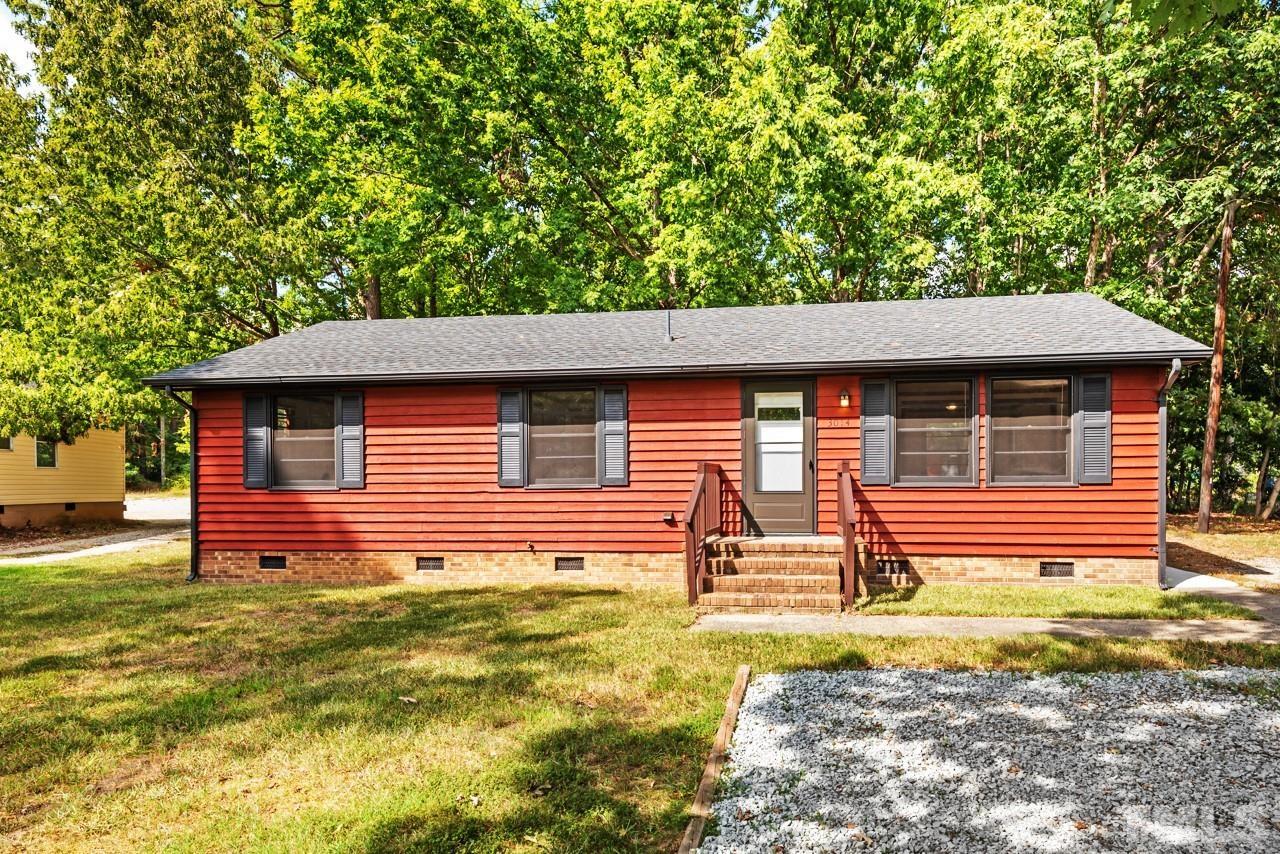 a backyard of a house with barbeque oven table and chairs