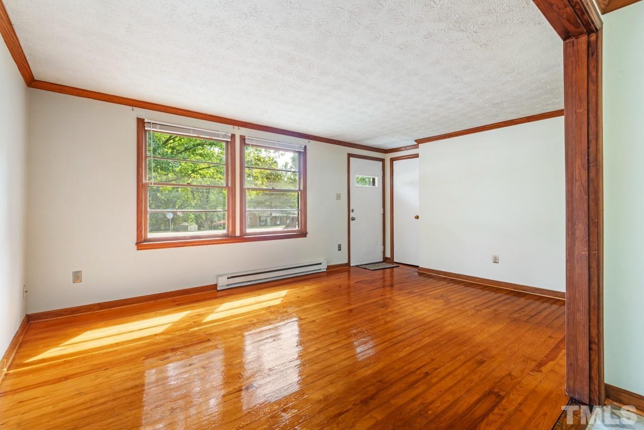 3014 Dearborn Drive Durham, NC 27704 - Photo 10 of 30 a view of an empty room with a window and wooden floor
